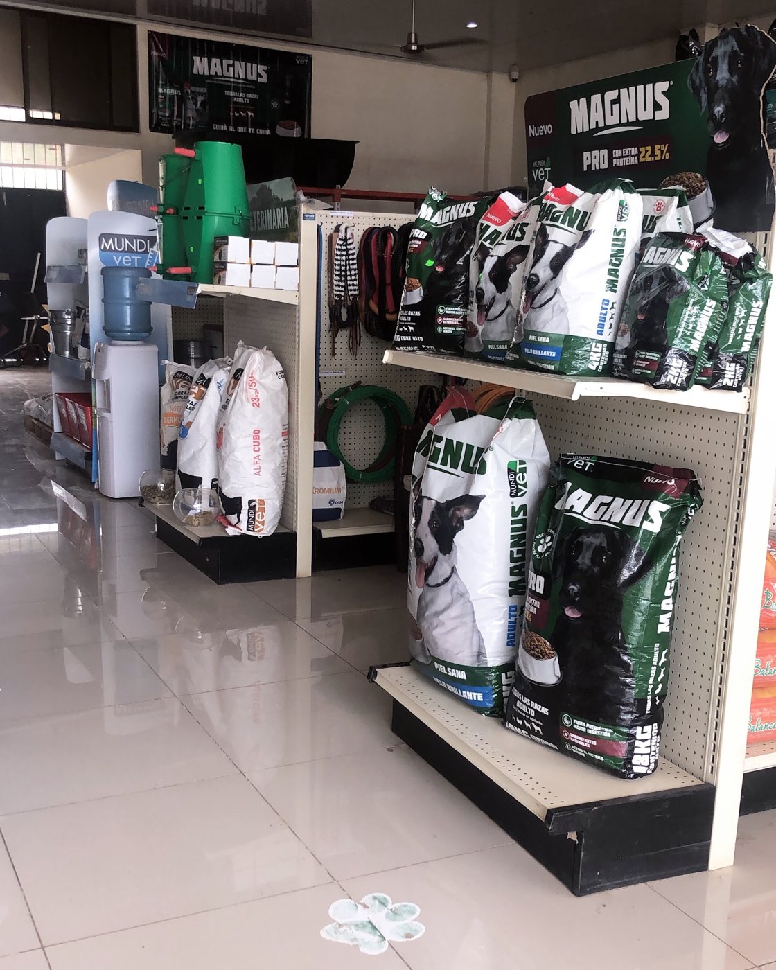 Interior de la tienda: estantes con sacos de alimento Magnus y forraje